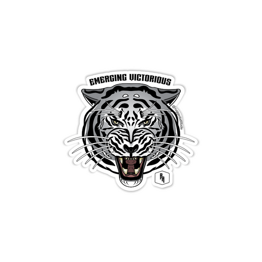 3x2.5 inch die cut sticker with the design of a white tiger and gothic calligraphy words "emerging victorious". Branded with Rugged Attitude logo.